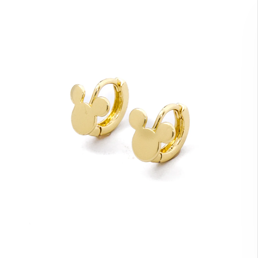 A pair of small gold hoop earrings feature a charm in the shape of a round head with two ears, resembling a playful mouse silhouette. The polished finish gives them a bright, shiny look, making them a fun and whimsical accessory. 