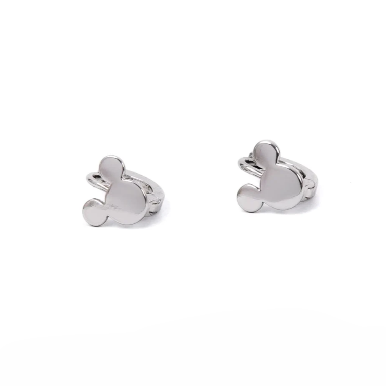 A pair of small silver hoop earrings feature a charm in the shape of a round head with two ears, resembling a playful mouse silhouette. The polished finish gives them a bright, shiny look, making them a fun and whimsical accessory.