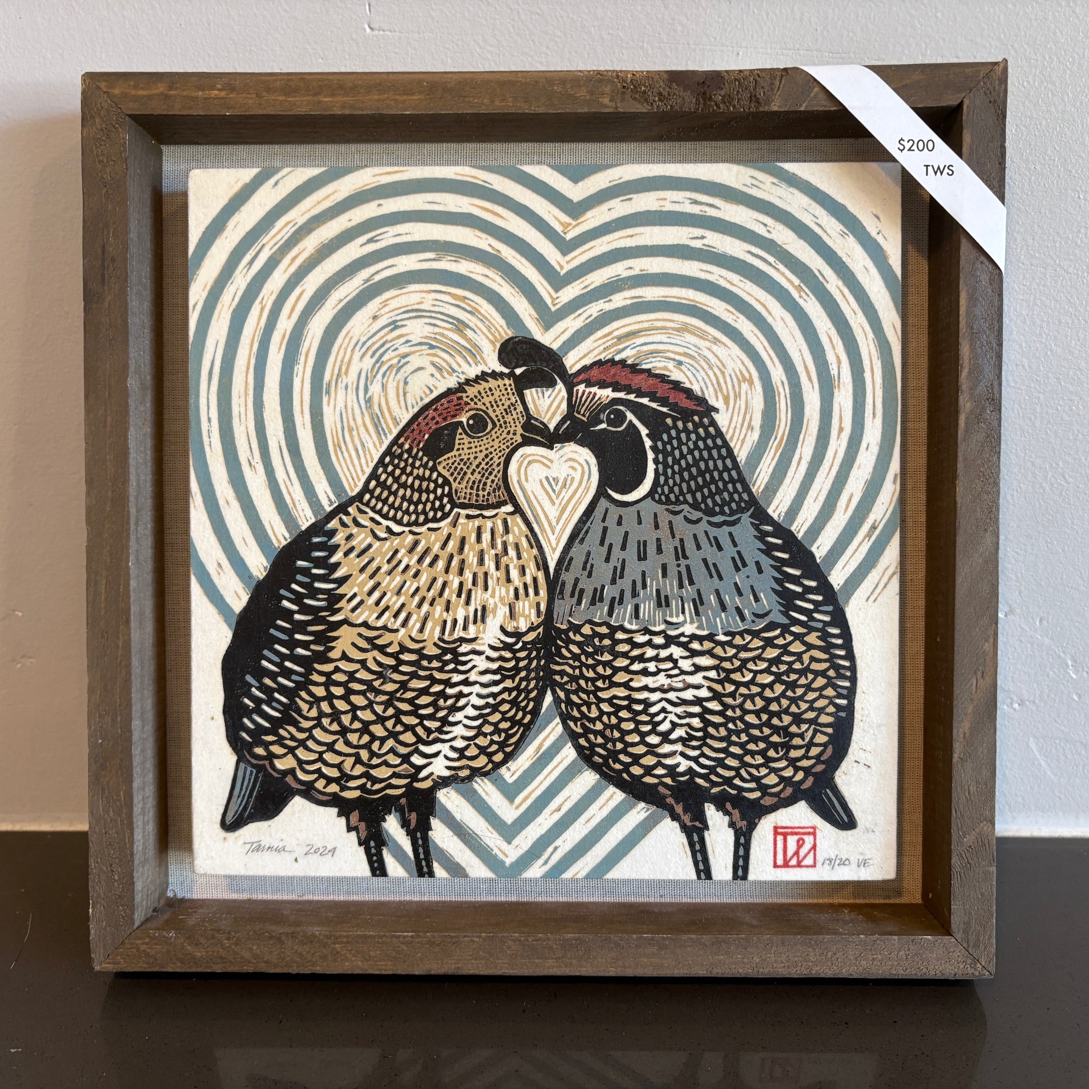 A linocut of two quails with their beaks and chests touching, forming a heart shape. There is expanding hearts behind them and one quail is yellow while the other is blue. 
