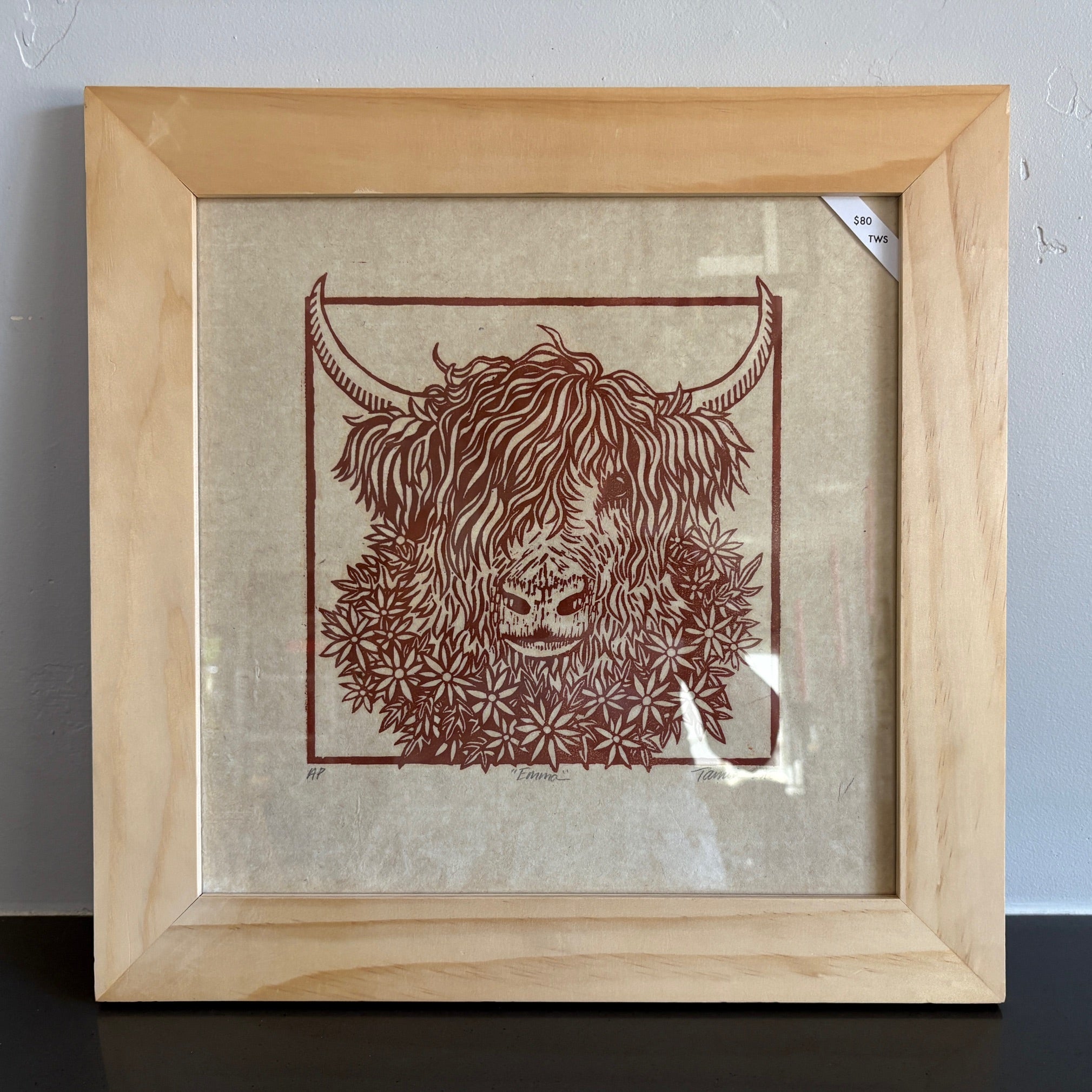 A simple line drawing with red ink of a highland cow with big horns and surrounded by daisies. 