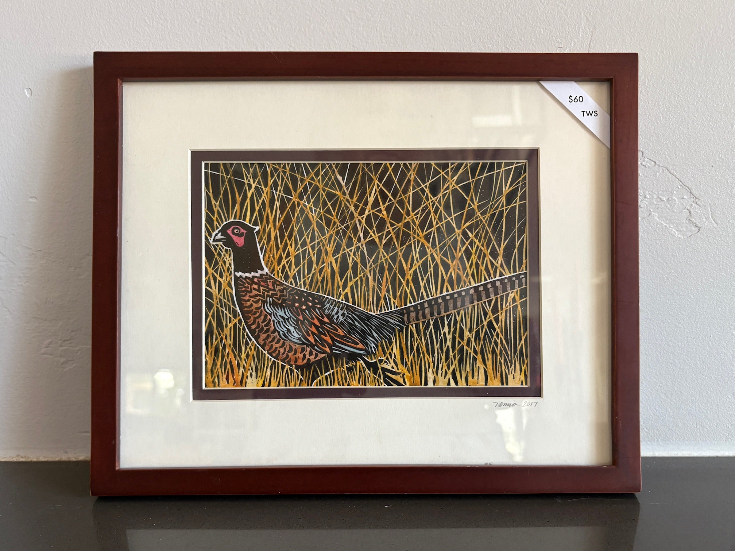 An orange pheasant surrounded by golden straw. 
