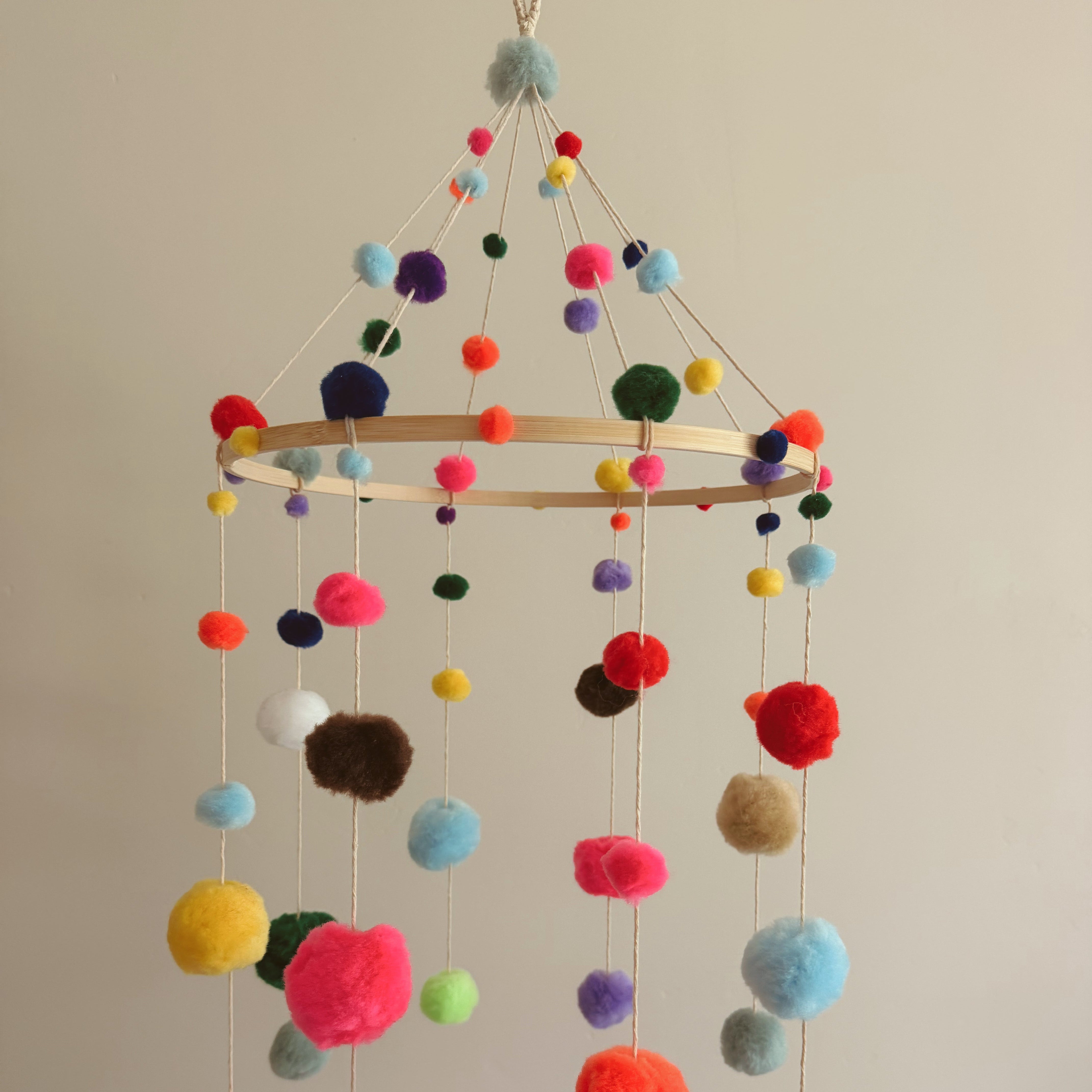 Simple baby mobile with colorful poms.