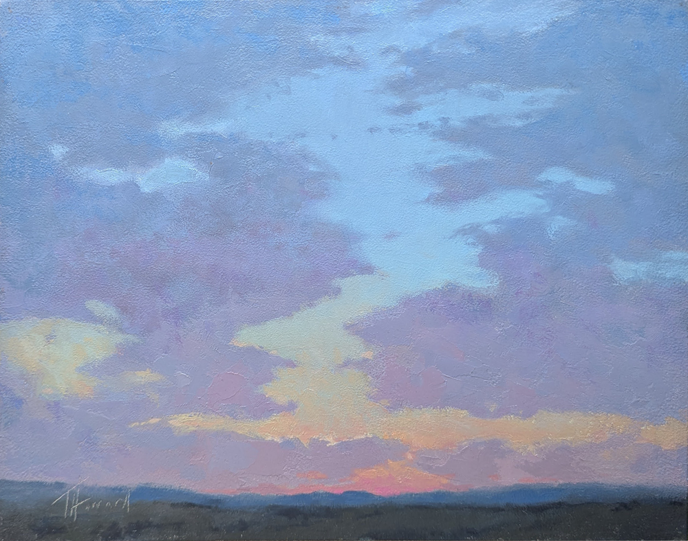 A dusky blue, purple, and yellow sky with scattered clouds. A very distant blue mountain range is below the big sky. 
