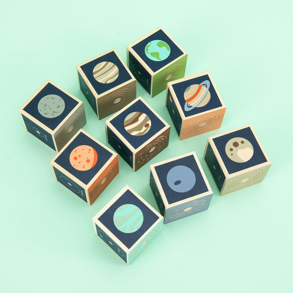 Mercury. Venus. Earth. Mars. Jupiter. Saturn. Uranus. Two debossed sides feature the planet’s symbol, name, and number of moons. The four printed sides reveal a planet illustration, diameter, location, and distance from the sun. This 9 block set honors all 8 planets in our solar system; plus a bonus dwarf planet, Pluto.
