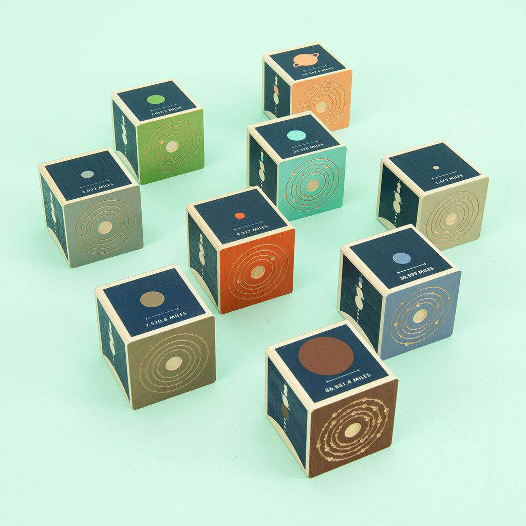 Mercury. Venus. Earth. Mars. Jupiter. Saturn. Uranus. Two debossed sides feature the planet’s symbol, name, and number of moons. The four printed sides reveal a planet illustration, diameter, location, and distance from the sun. This 9 block set honors all 8 planets in our solar system; plus a bonus dwarf planet, Pluto.