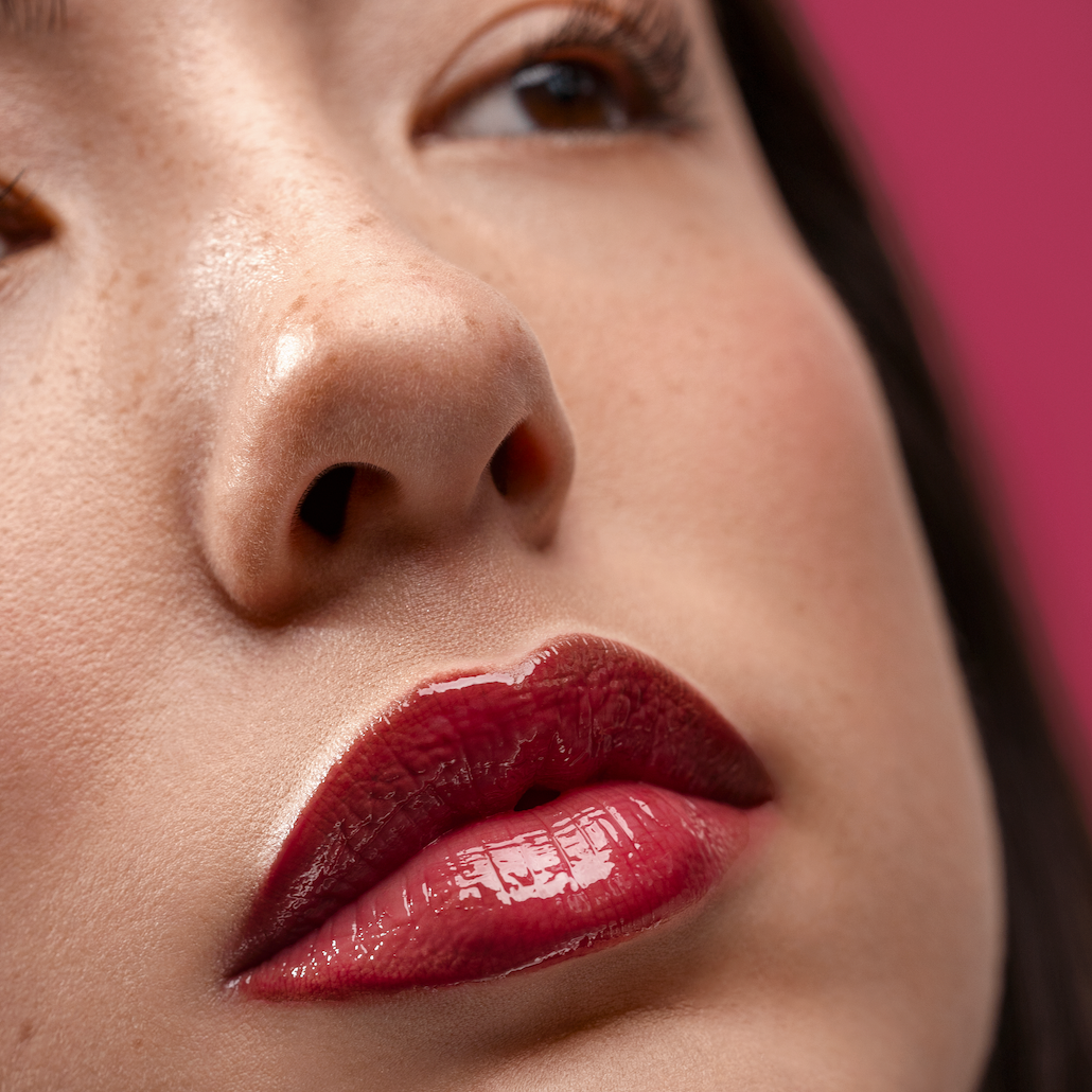 Close-up of a woman's lips with red lipstick against a blurred background