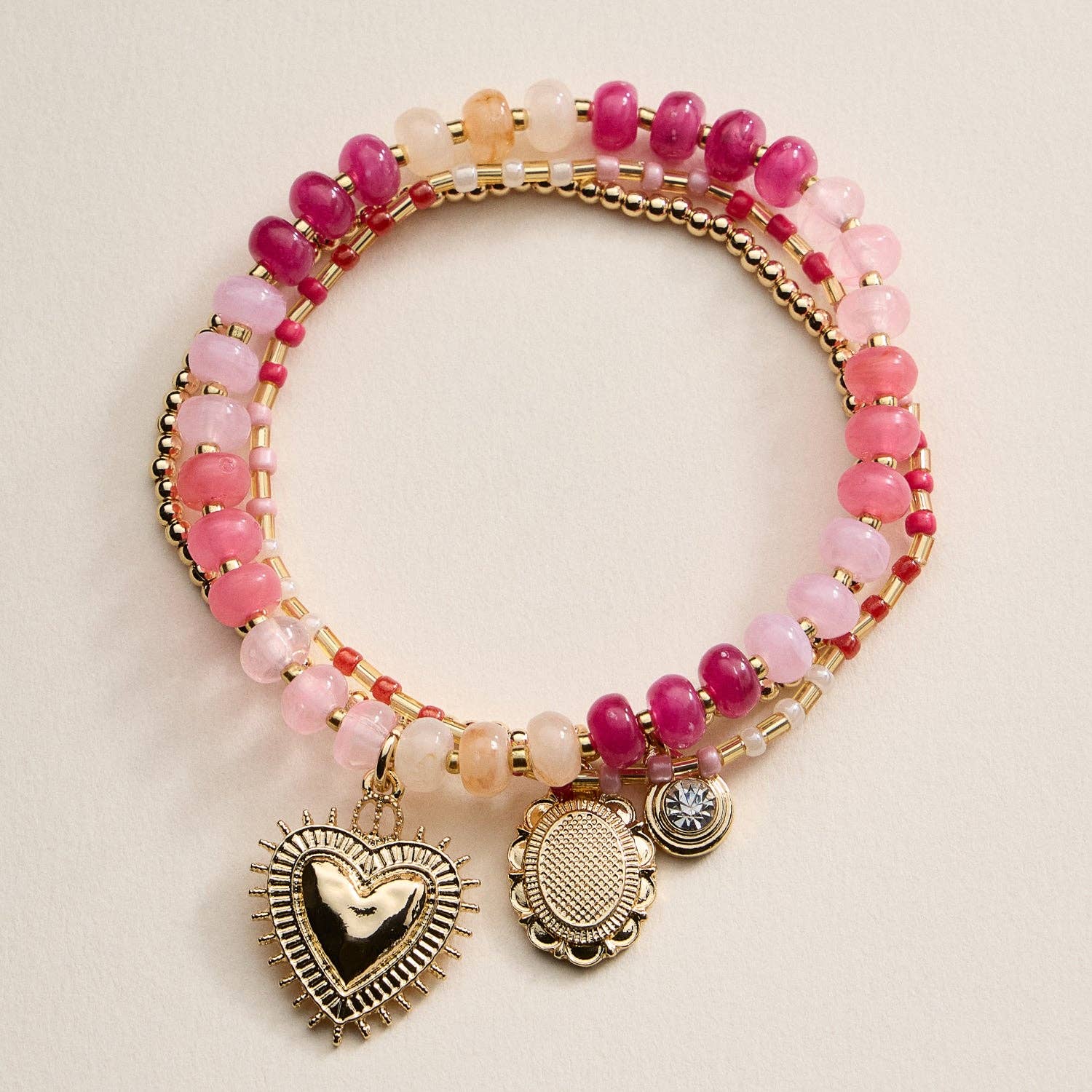 Bright and playful, this beaded bracelet set features three coordinating designs — a gold-tone beaded bracelet with charm pendants, a colorful stretch bracelet with a heart charm centerpiece, and a slim seed bead bracelet for a layered touch. Each piece adds a pop of color and shine, perfect for stacking or wearing solo for effortless charm and personality.

Details:

Material: Alloy, glass beads, acrylic beads, elastic cord
Design: Three-piece stretch bracelet set with mixed beaded textures and metallic