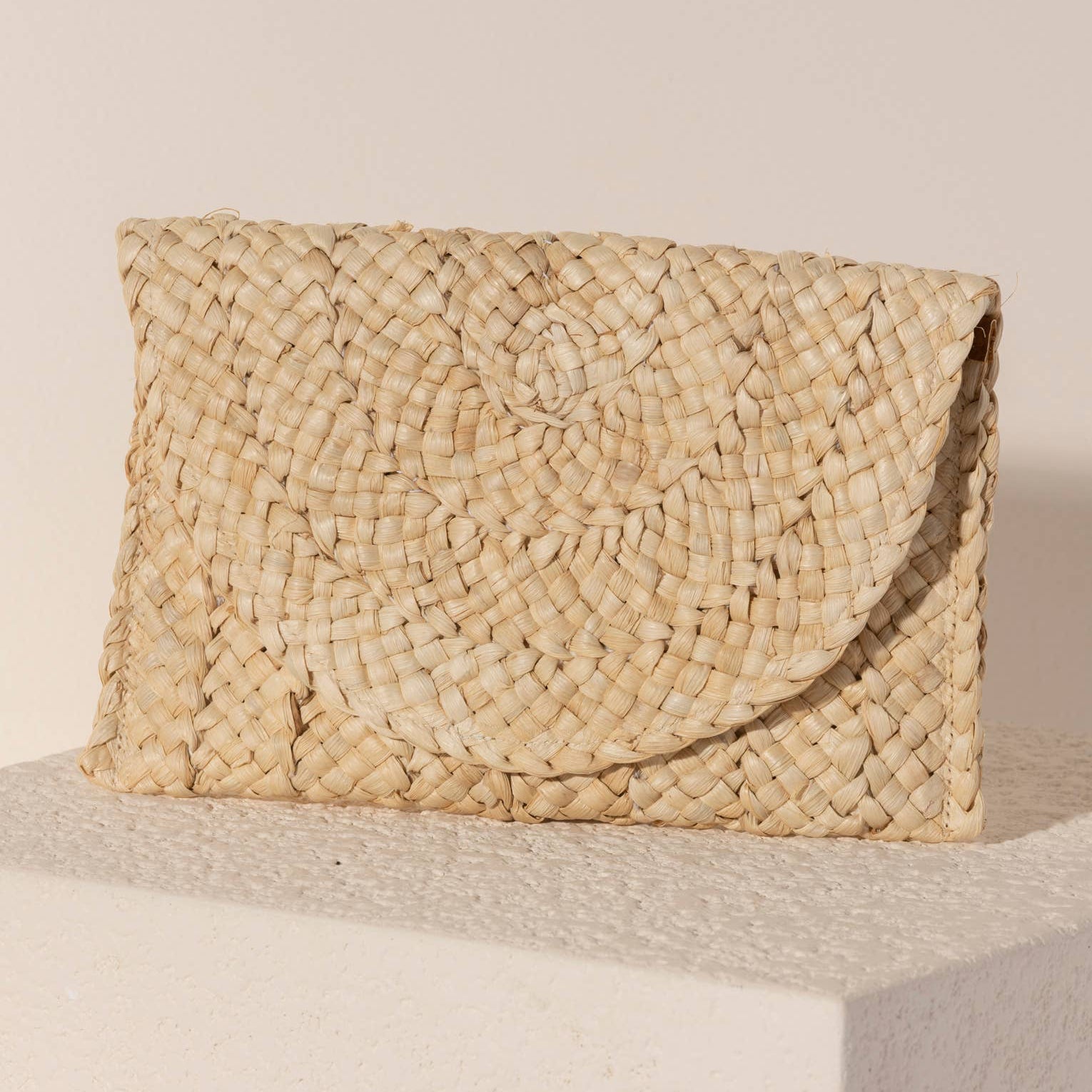 Introducing Shiraleah's Simonetta Clutch in natural. This clutch bag is crafted from corn husk and features a secure magnetic snap closure. Perfect for any occasion, the Simonetta Clutch is a part of Shiraleah's unique and thoughtful collections. Experience the special feeling of owning a Shiraleah product.