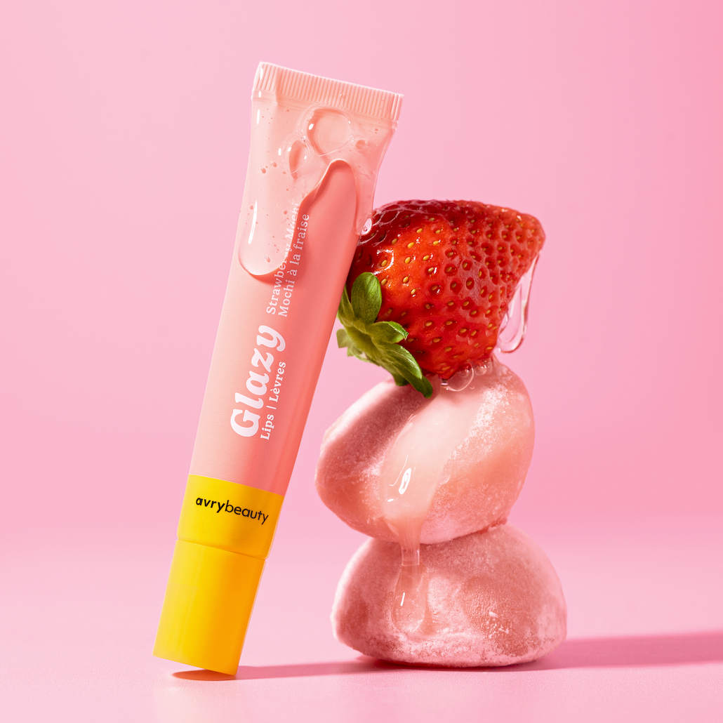 Tube of Glazy lip balm with a strawberry on a pink background
