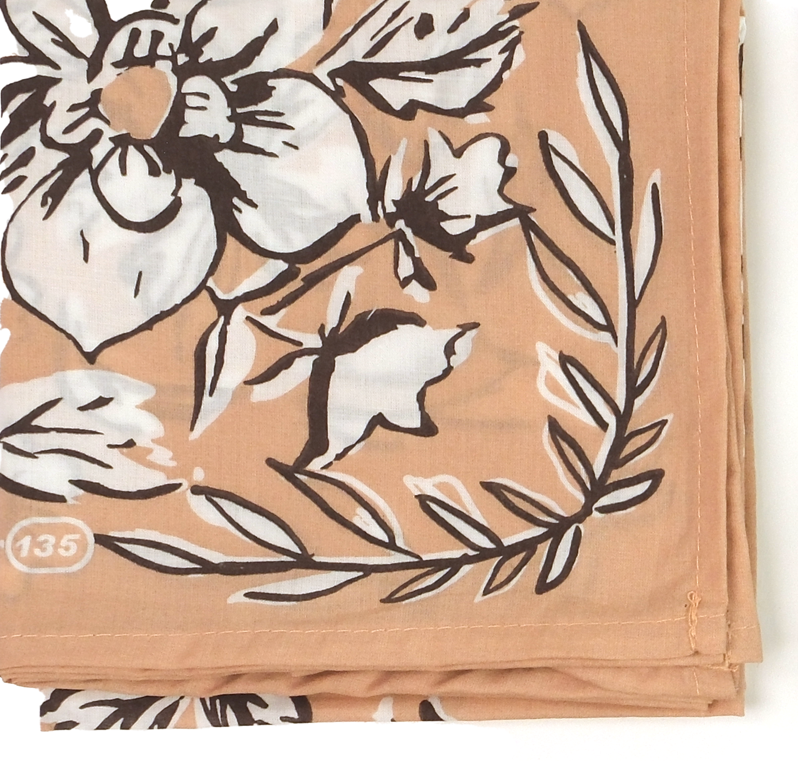Floral patterned fabric with black and white flowers on a beige background
