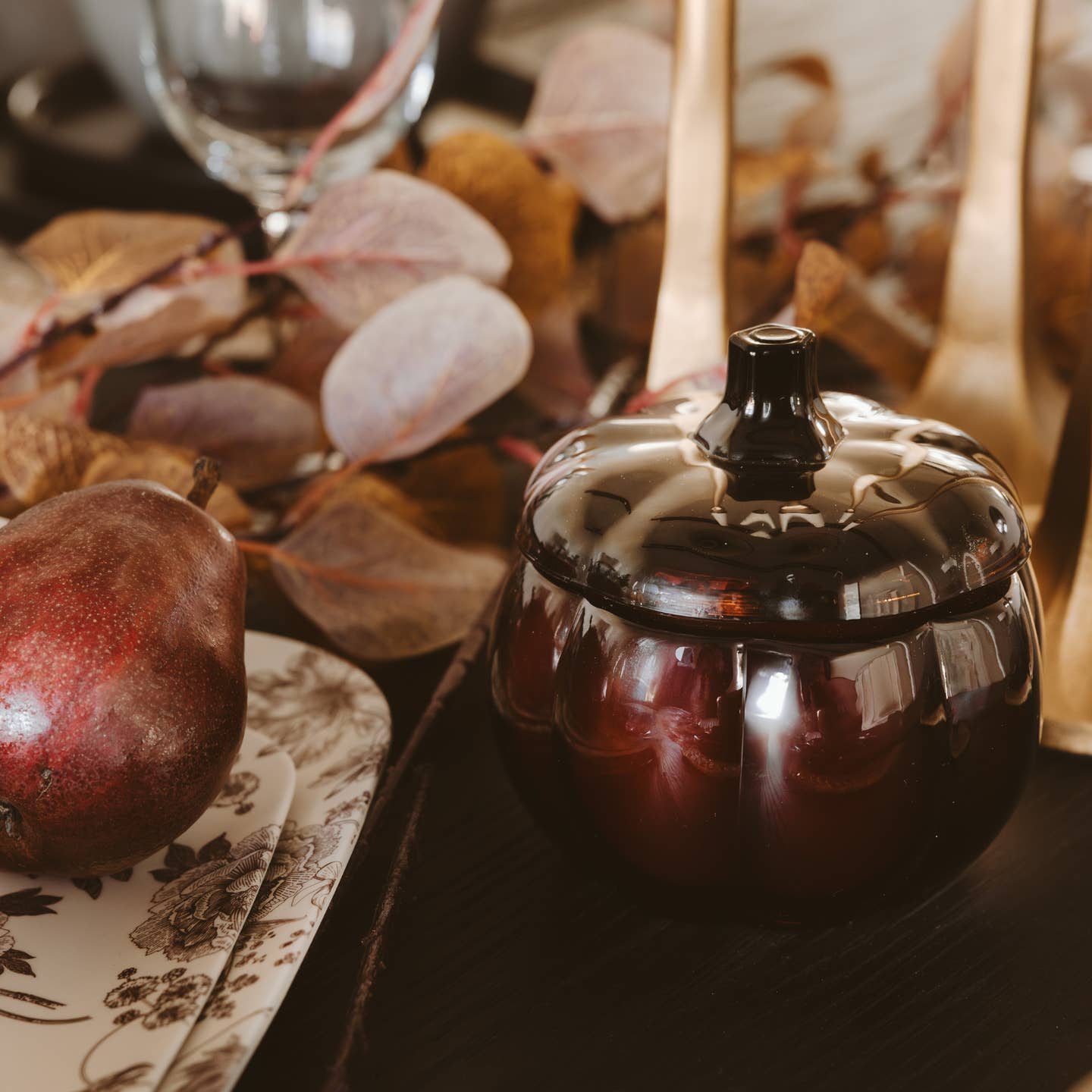 Decorative black pot on a table with autumn-themed elements