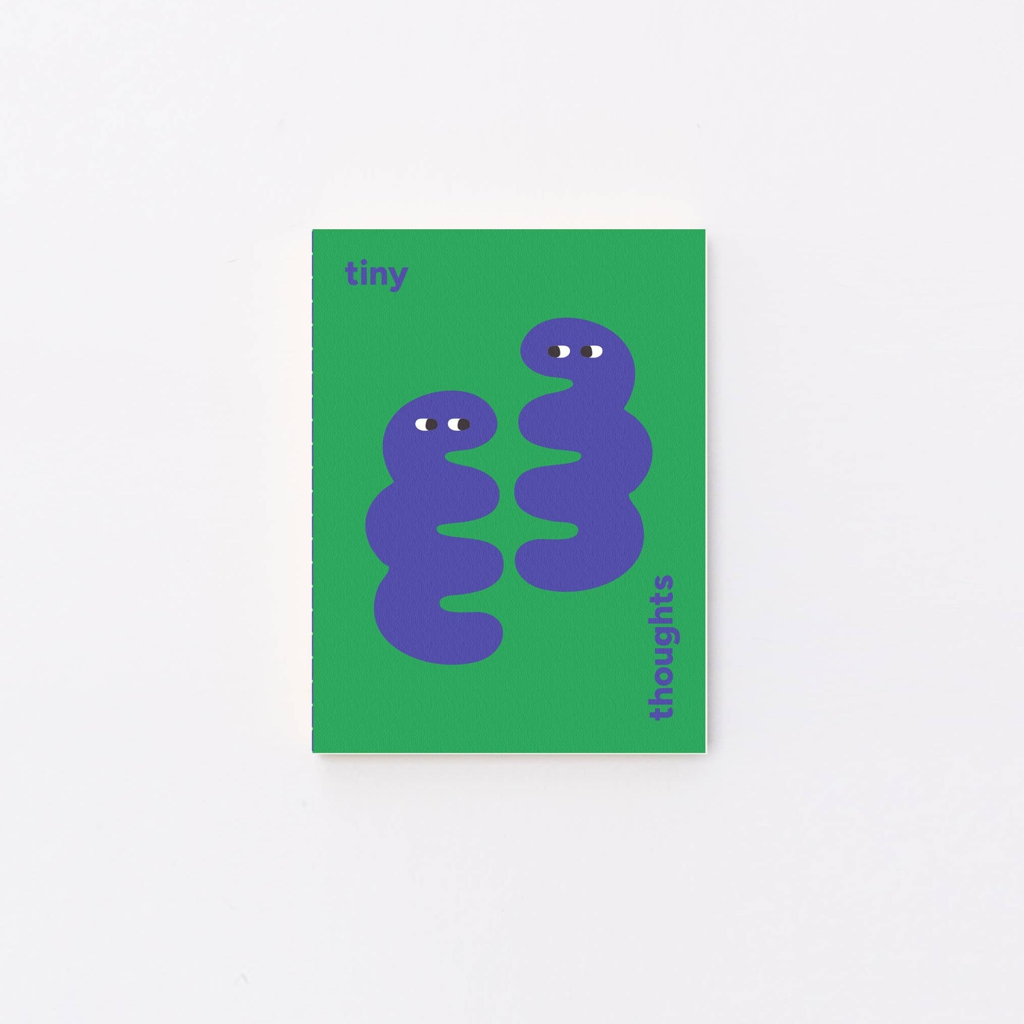 A small green notebook with a minimalist illustration of two purple coiled snakes on the front, photographed against a plain white background.