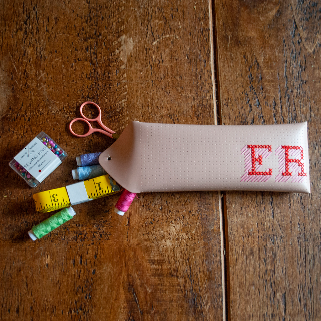 Stitch your own way - this envelope pocket is ideal as a pencil or glasses case and allows you to sew any unique design. Whether you stitch initials, a slogan or the sunglasses template included, it opens out fully for easy stitching. It also opens 2 ways, so it can open from the side or from the top - just pop the metal buttons to fold up whichever way you prefer. The Navy pouch comes with teal & gold thread &amp; needle wrapped on our pen thread-board. It includes our 3D alphabet template to add initials