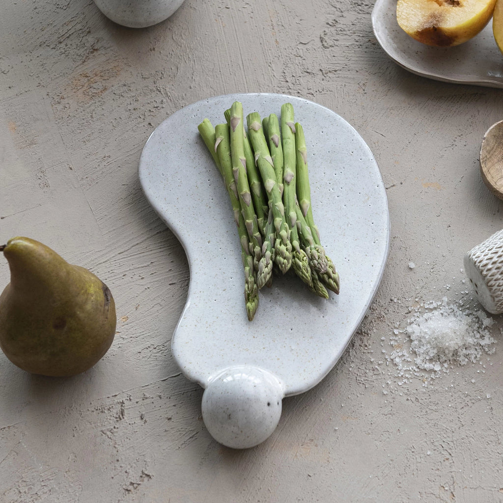 The tray is made of high-quality and durable stoneware that is easy to clean and care for. This stoneware tray with ball and reactive glaze in cream is an excellent choice for self-care or special occasions.