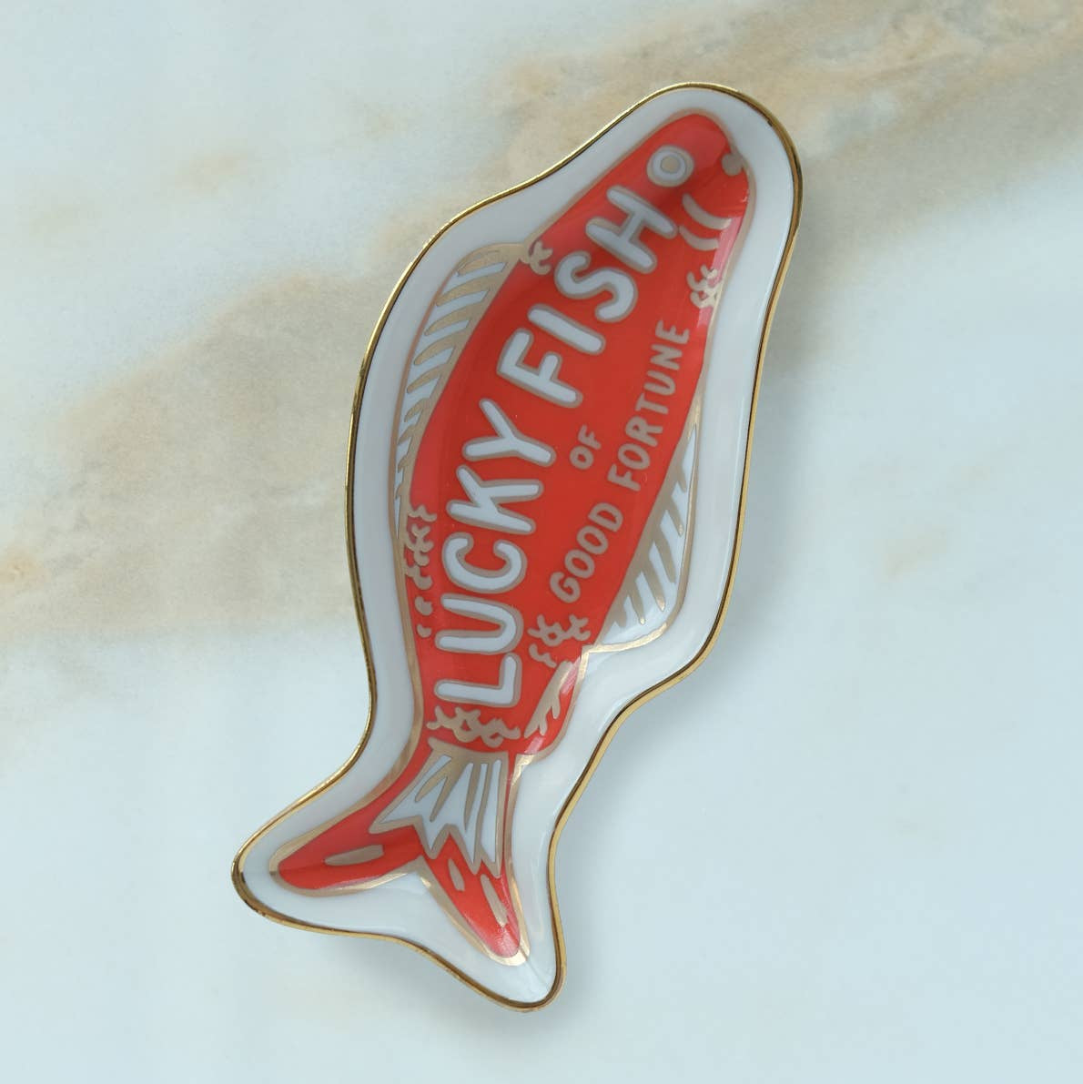Lucky Fish pin with red and gold design on a light background