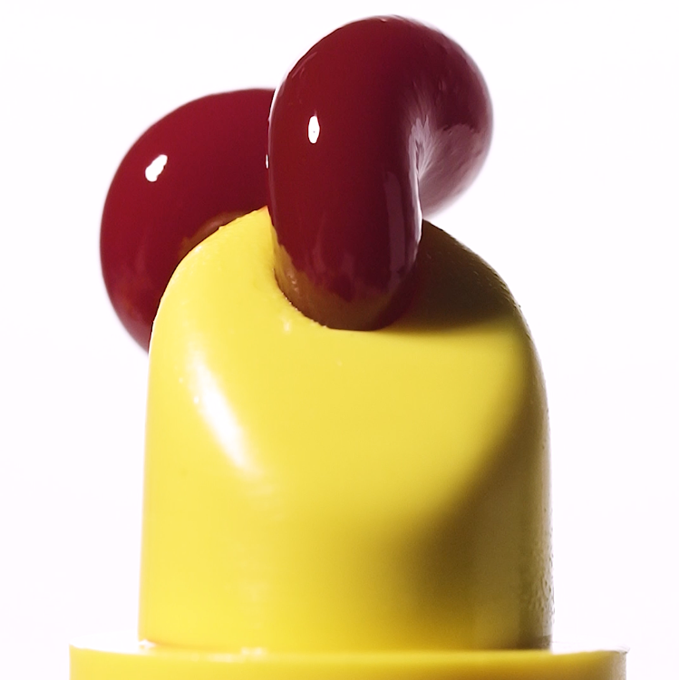 Yellow plastic object with red knobs on a white background