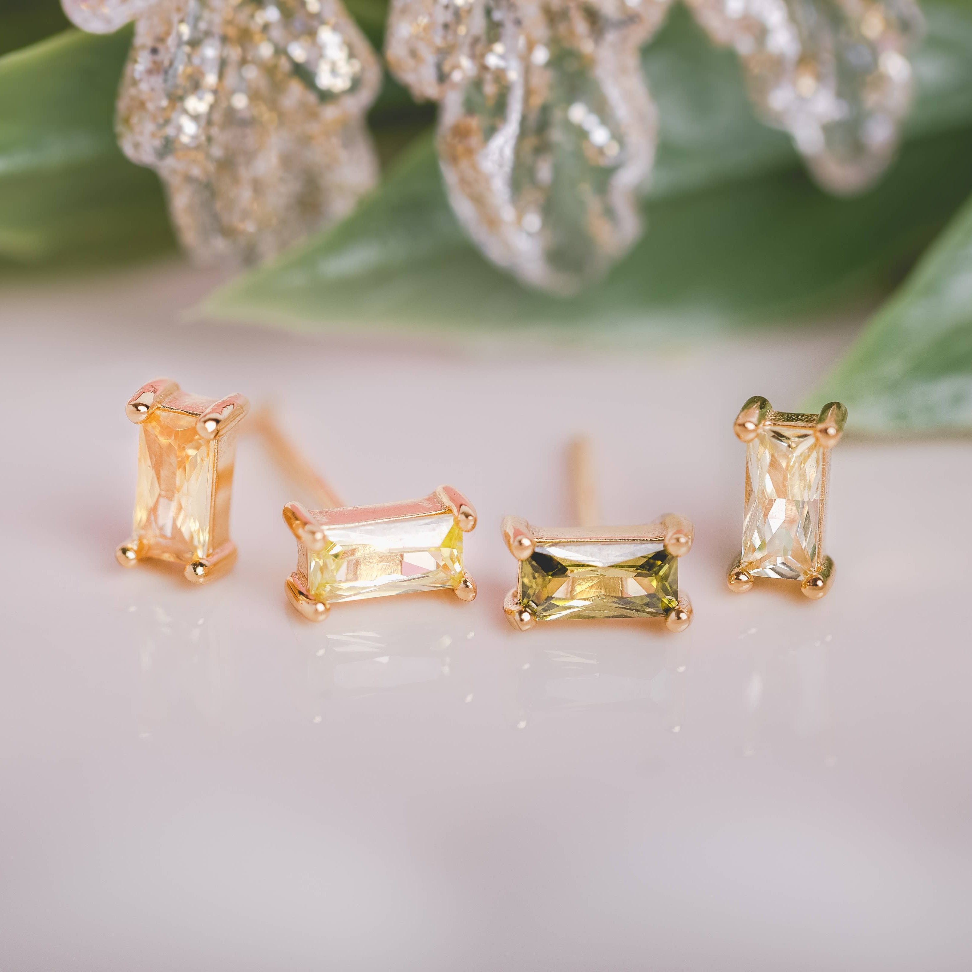  Birthstone Ombre Baguette Stud Earring Set, a collection of four stunning earrings crafted in 18k gold plated with an anti-tarnish coating. This set of stud earrings showcases the ombre effect, seamlessly blending hues from light to dark, creating a captivating visual representation of your birthstone's color spectrum. 