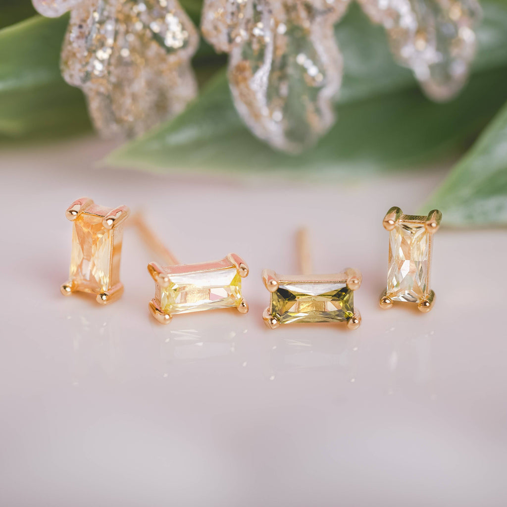  Birthstone Ombre Baguette Stud Earring Set, a collection of four stunning earrings crafted in 18k gold plated with an anti-tarnish coating. This set of stud earrings showcases the ombre effect, seamlessly blending hues from light to dark, creating a captivating visual representation of your birthstone's color spectrum. 