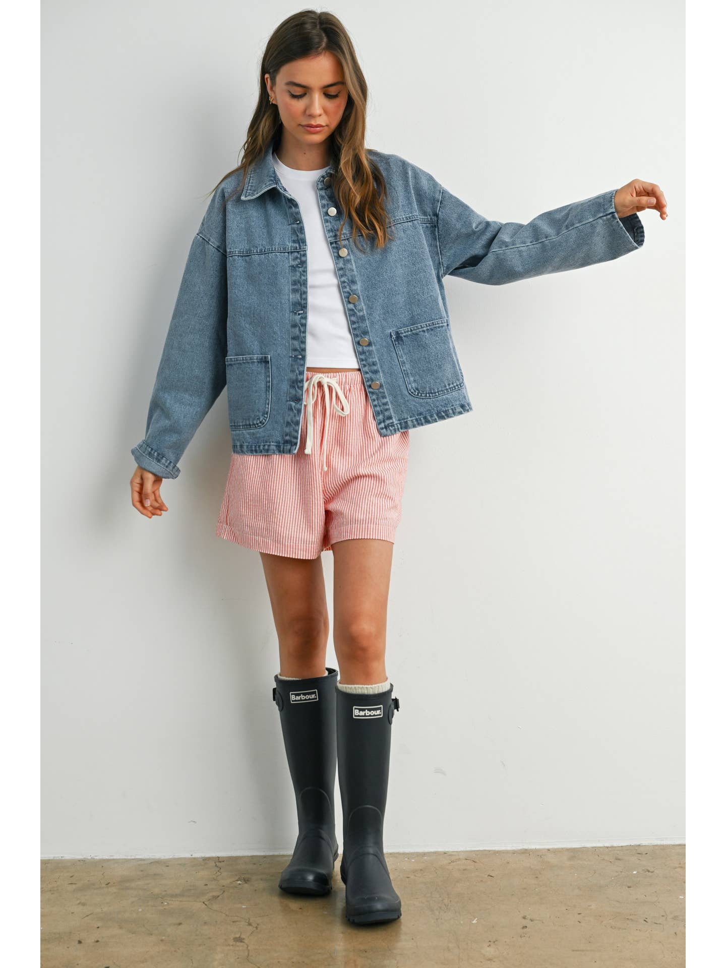 Medium wash denim jacket with silver buttons, box pockets, and collar. 