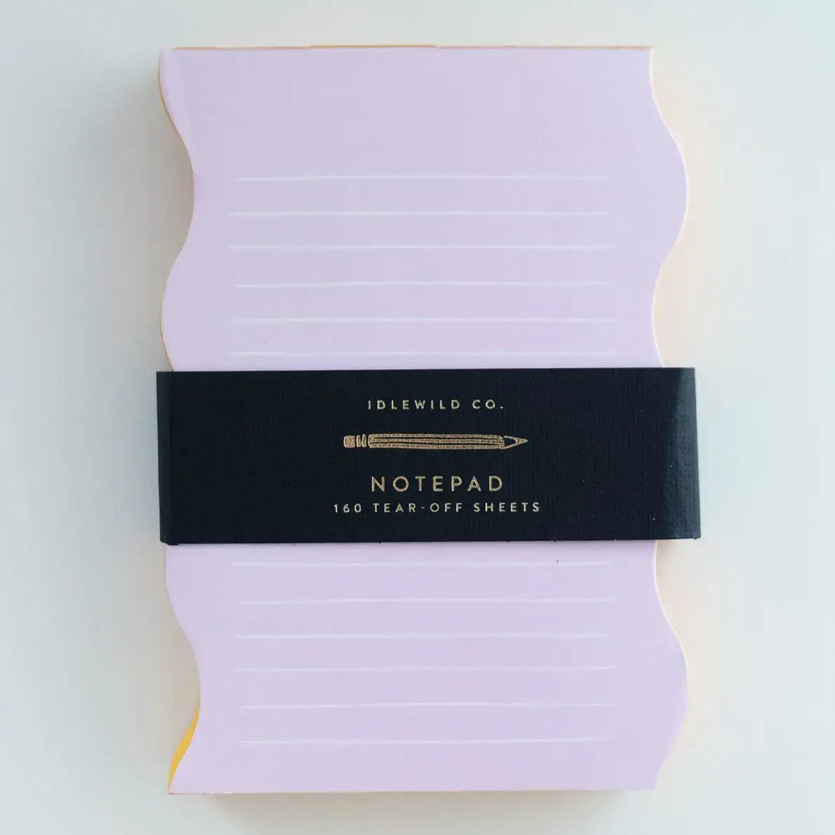 Purple notepad with a black band featuring 'Idlewild Co.' branding on a light gray background