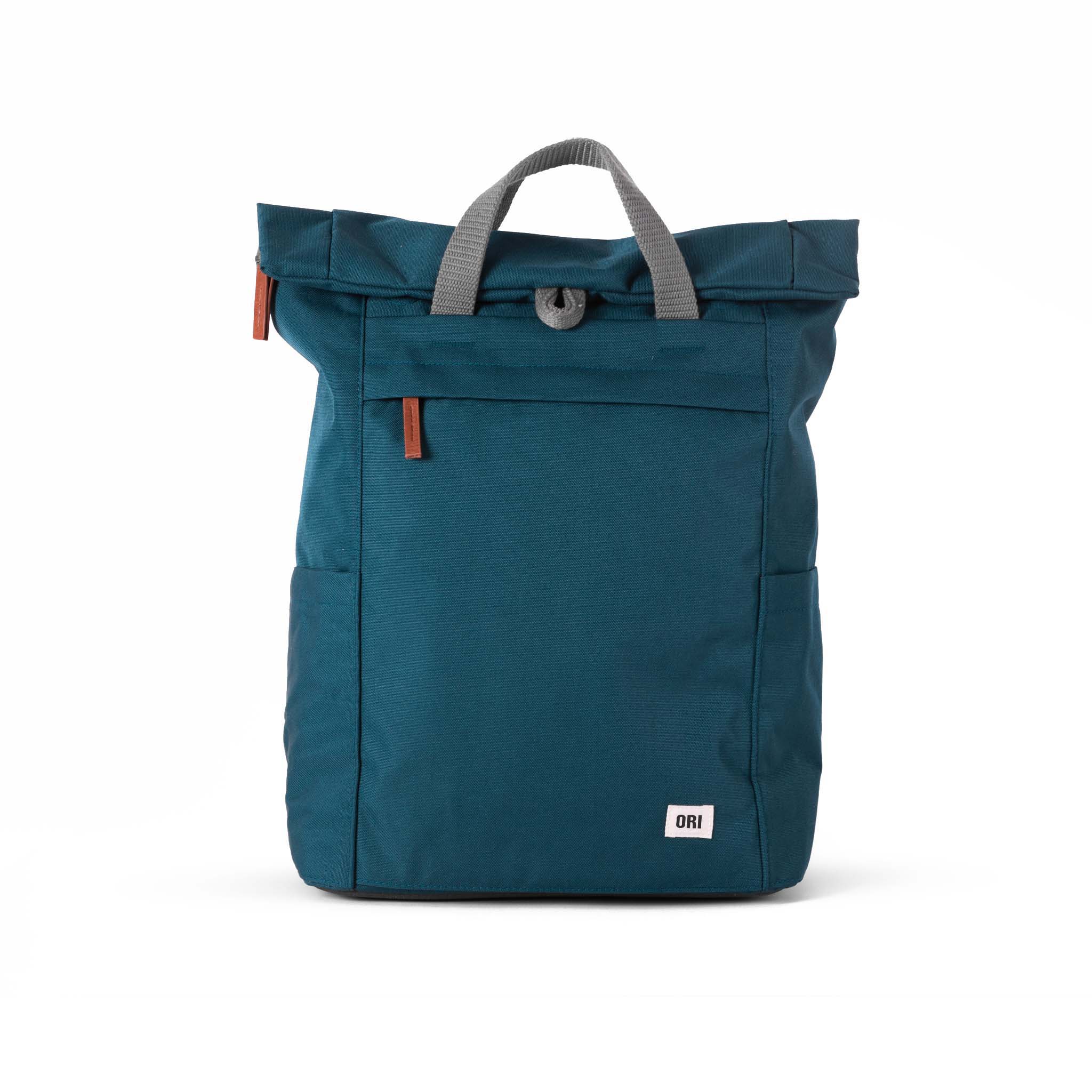 Rock the outdoor look with our minimalist-design, roll-top backpack with a large front pocket with a chunky zip. Teal

This weather-resistant bag has extra storage space, a padded laptop or tablet sleeve and loads of pockets. Made using recycled Canvas made from plastic waste and coated to make it water-resistant, our canvas material is weather-resistant, lightweight, and as durable as all our ORI London bags.