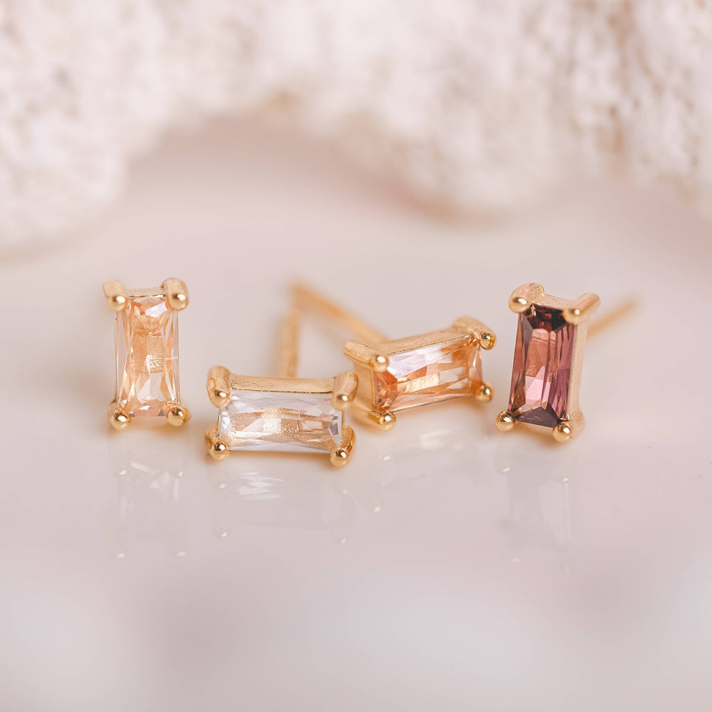  Birthstone Ombre Baguette Stud Earring Set, a collection of four stunning earrings crafted in 18k gold plated with an anti-tarnish coating. This set of stud earrings showcases the ombre effect, seamlessly blending hues from light to dark, creating a captivating visual representation of your birthstone's color spectrum. 