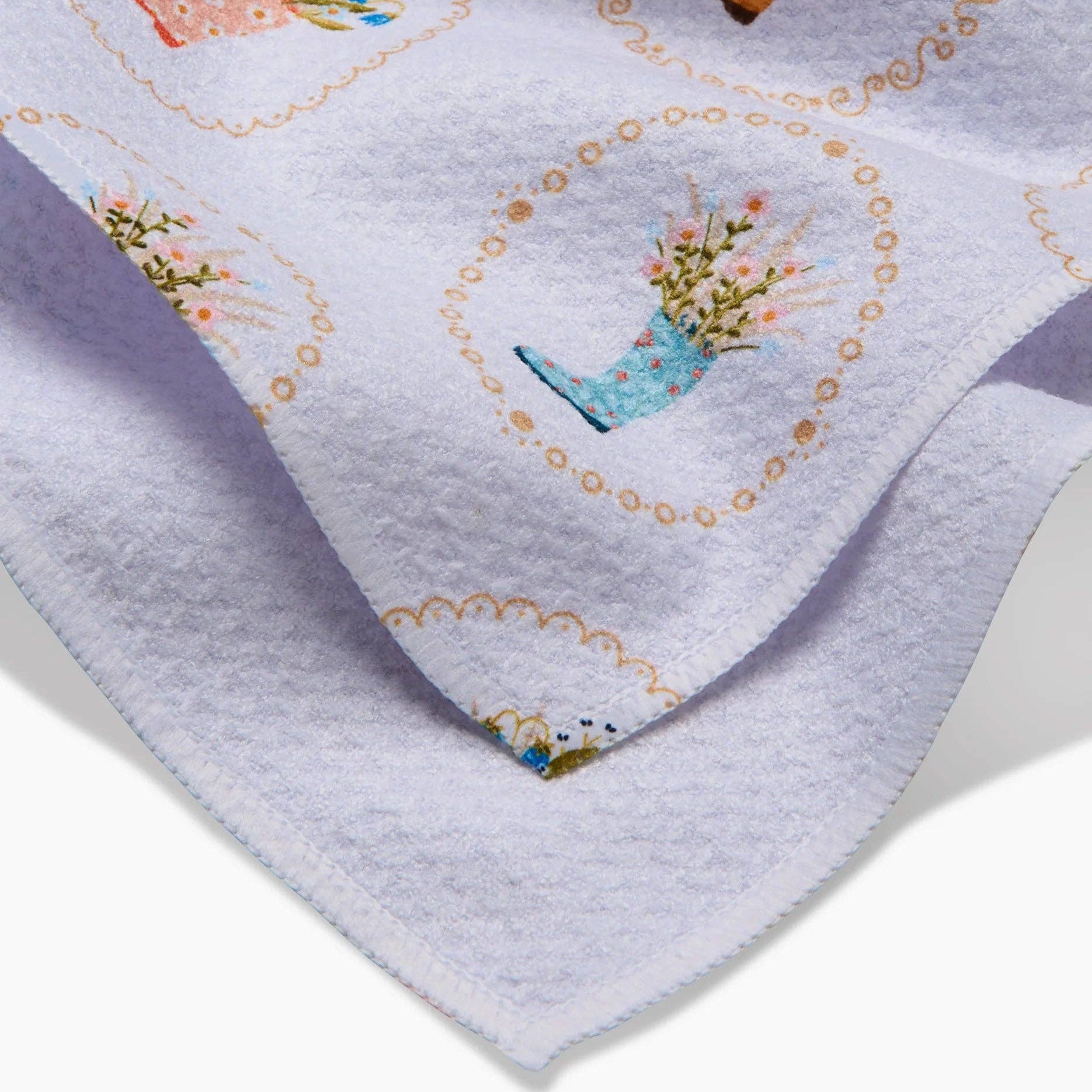 Embroidered fabric with floral and boot designs on a gray background