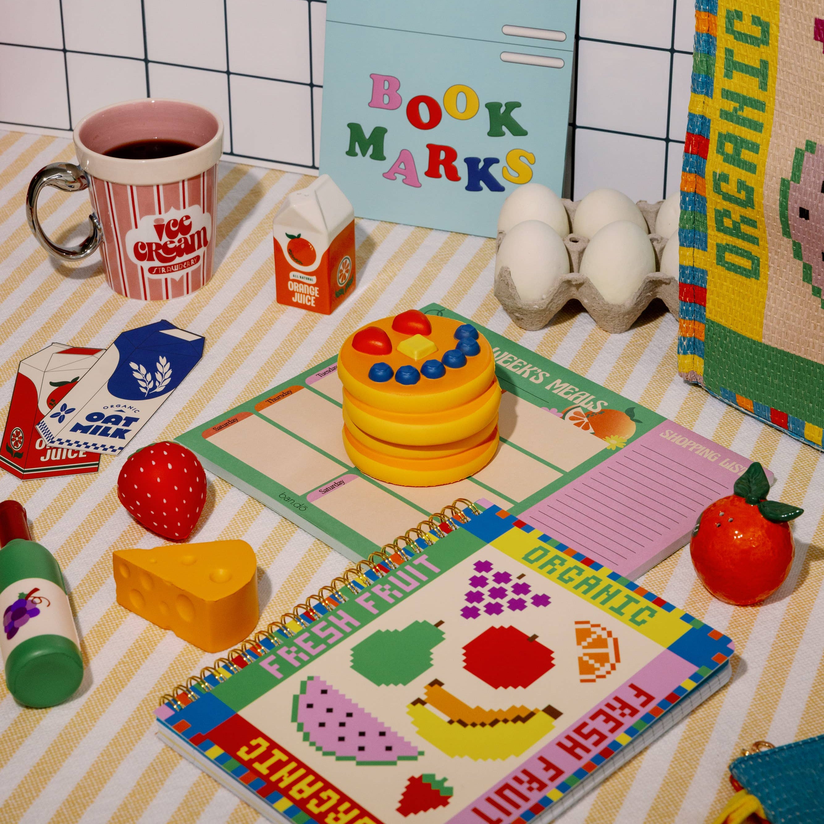 Colorful children's play area with toys, books, and stationery on a checkered floor.