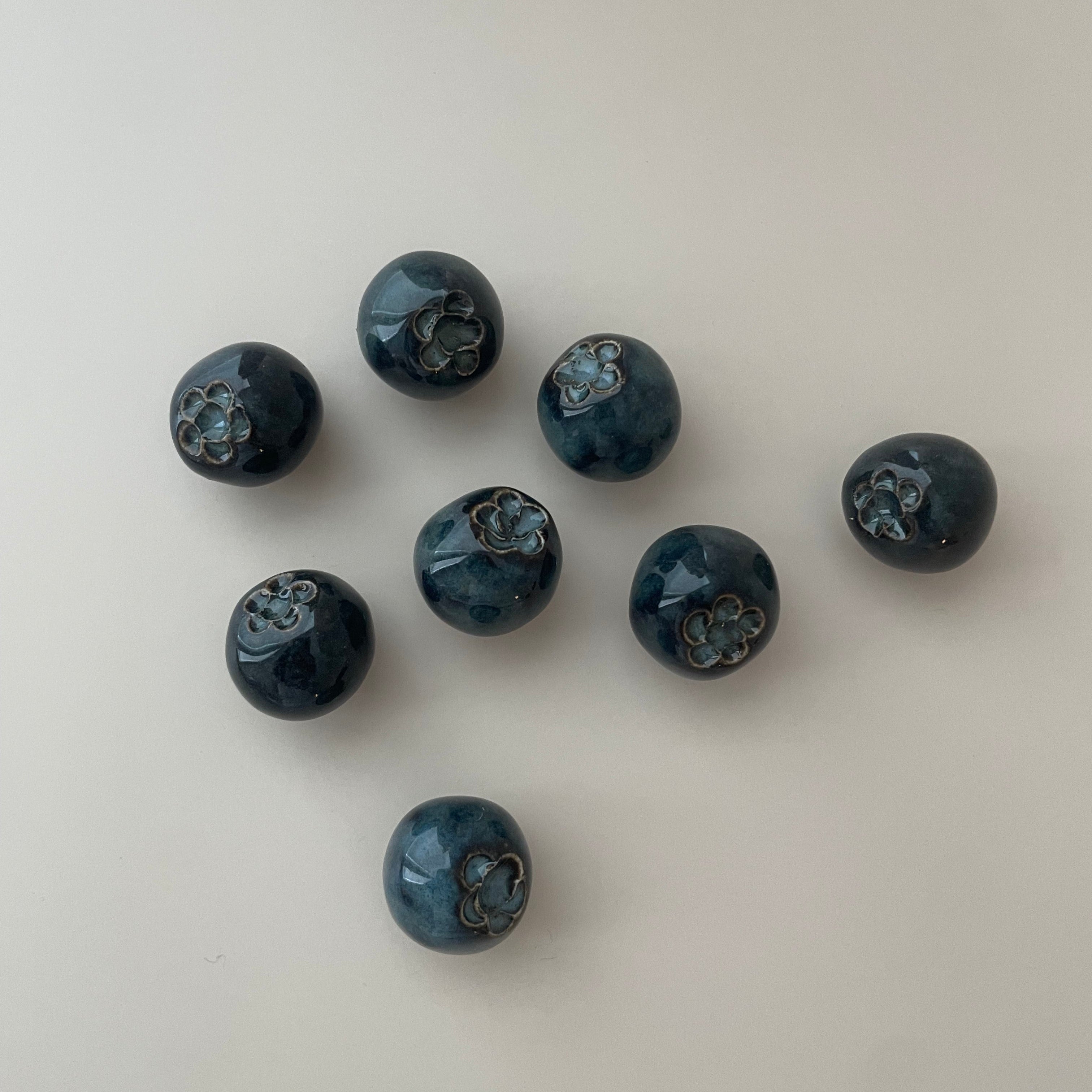 round detailed blueberry magnets with a dark blue glaze
