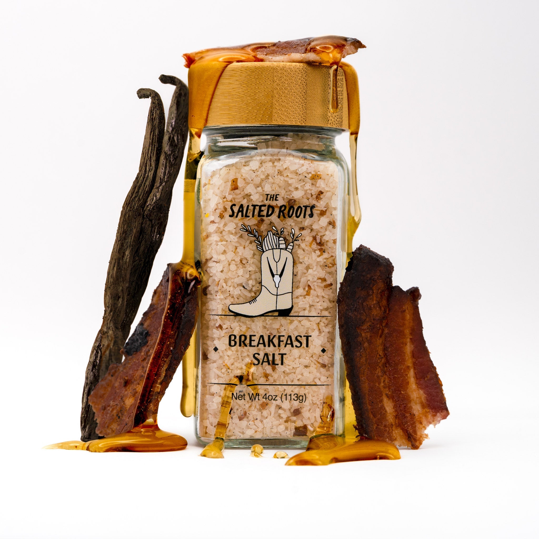 Glass salt jar with wooden lid. Vanilla bean, bacon, and syrup drip of lid. 
