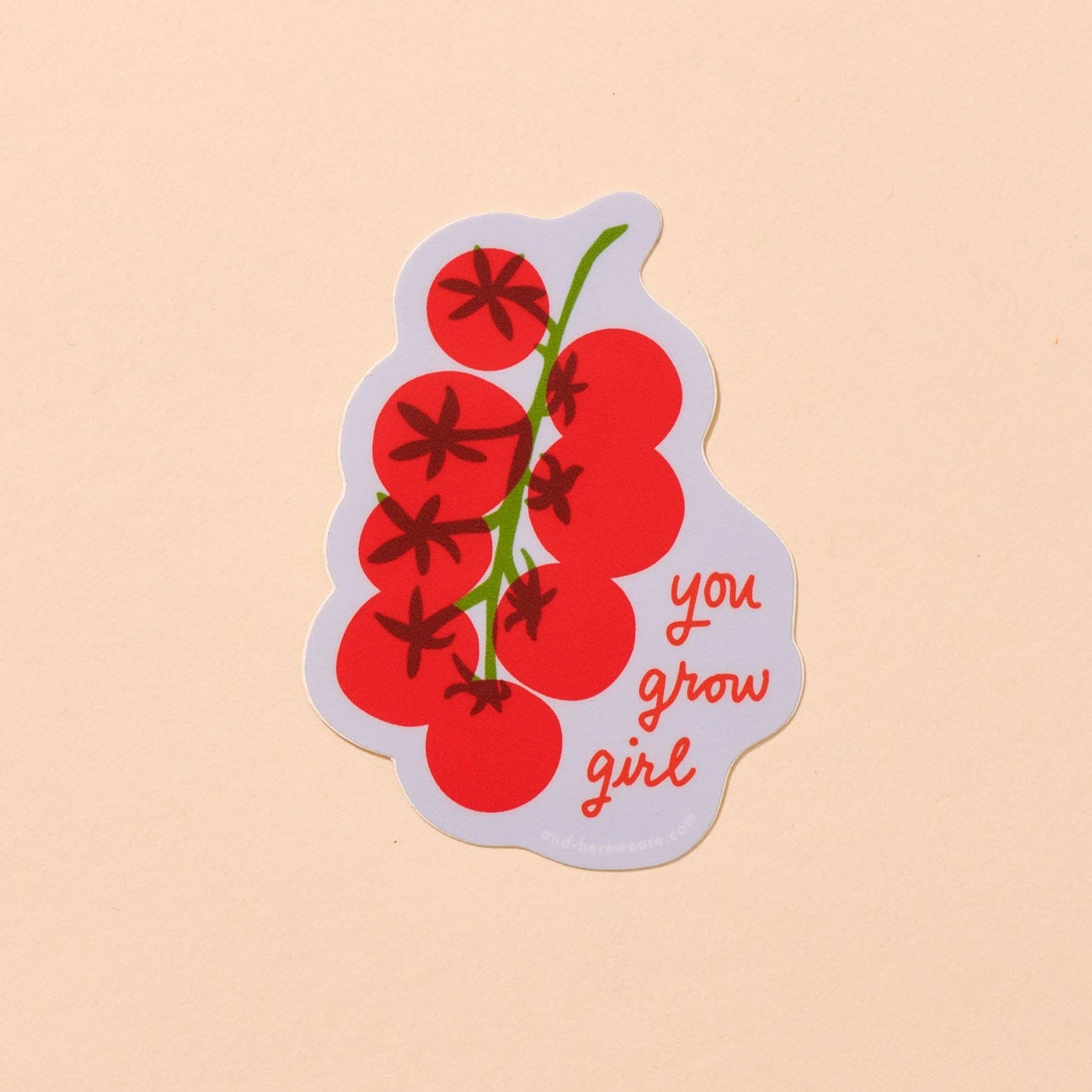 Sticker with red berries and 'you grow girl' text on a beige background