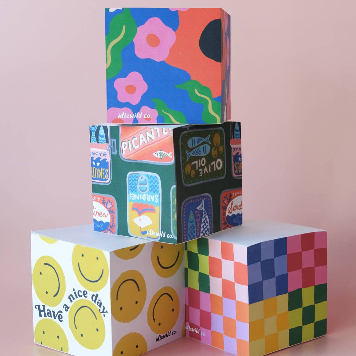 Colorful paper cubes with various designs on a pink background