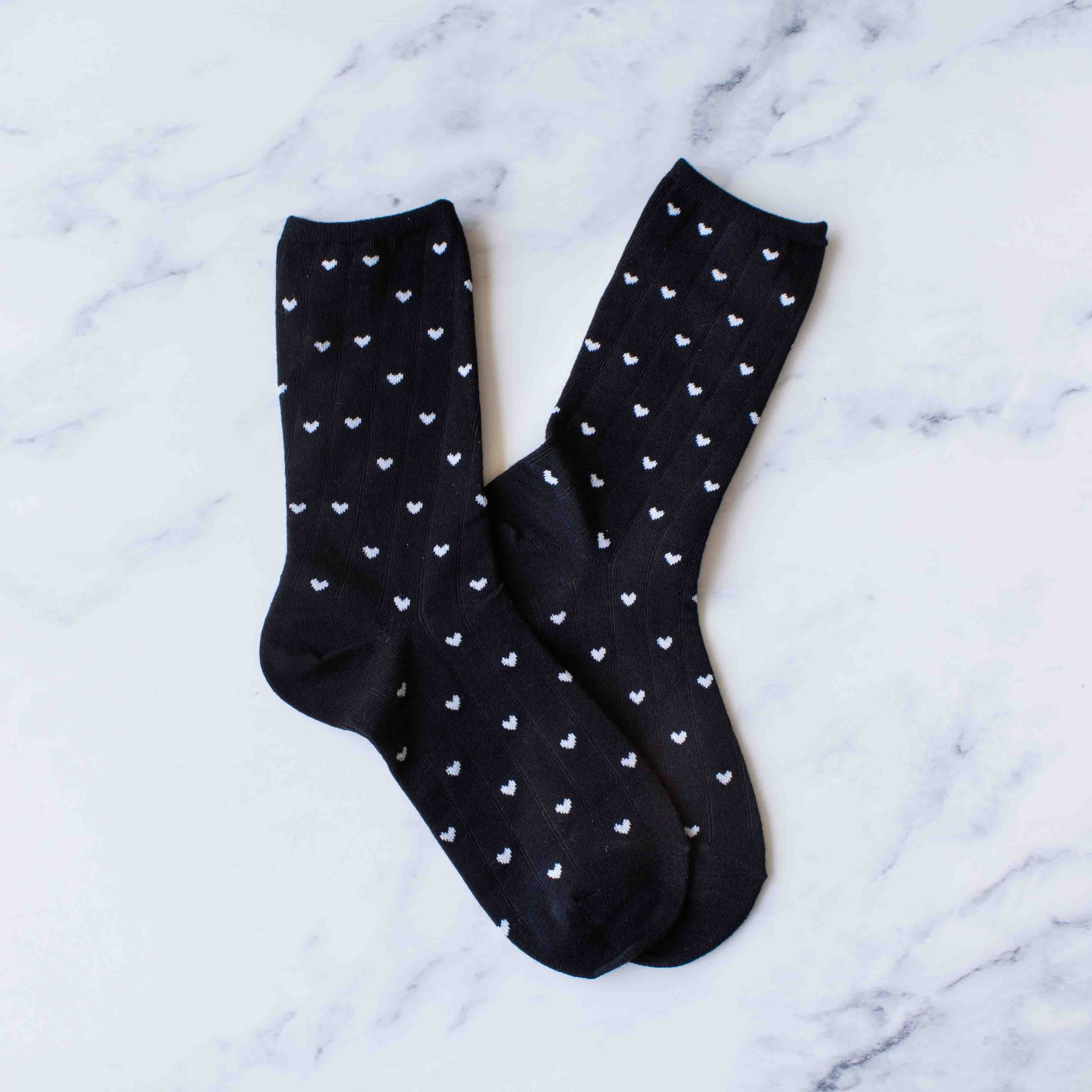 These charming crew socks bring a playful touch to your everyday wardrobe. Featuring delicate white hearts scattered across a classic black background, they're perfect for expressing your personality with every step. The casual crew cut offers comfortable coverage and pairs effortlessly with sneakers, loafers, or boots. Made for all-day wear, these socks are an easy way to add a little warmth and whimsy to your day.

Details:

Adult Size
80% Cotton ,15% Spandex, 5%Polyester