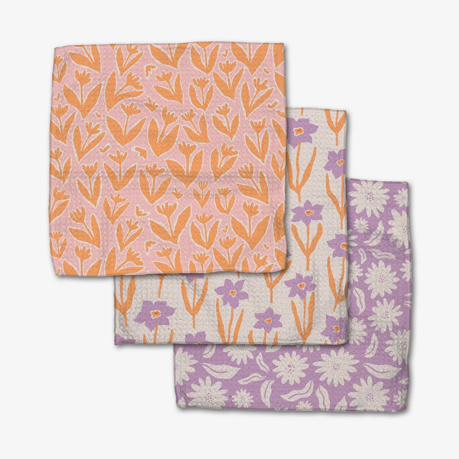 Three floral-patterned cloths stacked on a white background