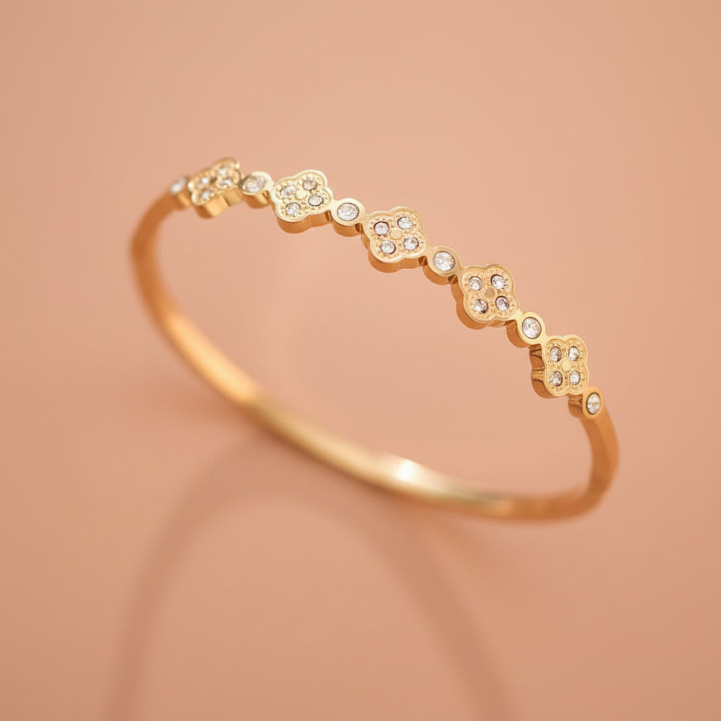 Elevate your everyday style with this 18K gold plated stainless steel bangle bracelet, featuring stunning inlayed crystals. With an inner oval diameter of 2.36", this piece combines luxury with practicality. Hypoallergenic, waterproof, and tarnish-resistant, it's designed to withstand daily wear. To maintain its radiant finish, avoid prolonged contact with lotions, perfumes, and cleaning products. A timeless accessory that transitions seamlessly from day to night.