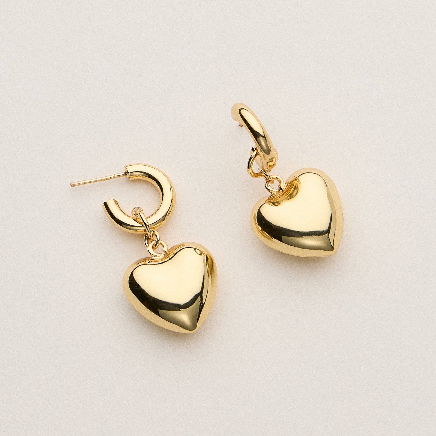 Add a touch of bold romance to your everyday look with these 18K gold dipped heart hoop earrings. Featuring a chunky hoop and puffed heart charm, these earrings are available in a radiant gold finish. Designed to make a statement while staying lightweight and wearable, they’re the perfect accessory for elevating any outfit—from casual to chic.