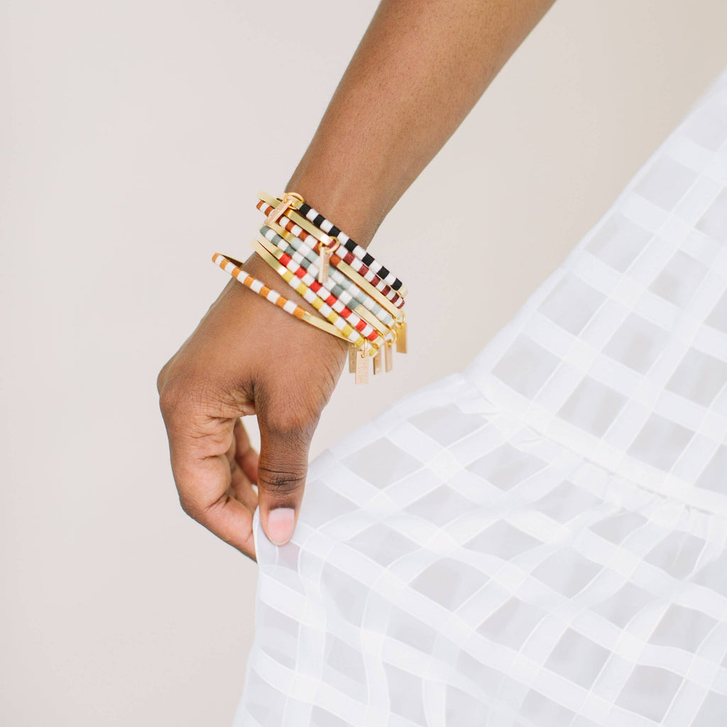 You'll be smitten with the Checkerboard Bangle. The soft cotton fibers hopscotch playfully between the vintage-inspired colorways and the classic natural hue to create a statement that will add the finishing touch to your artful look. Sage / Gold color.
