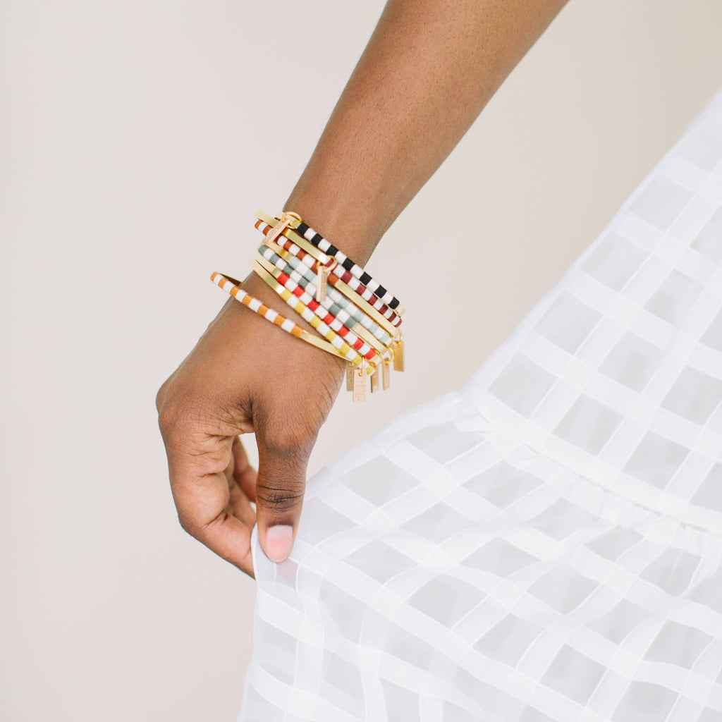 You'll be smitten with the Checkerboard Bangle. The soft cotton fibers hopscotch playfully between the vintage-inspired colorways and the classic natural hue to create a statement that will add the finishing touch to your artful look. Chamomile / Gold color.
