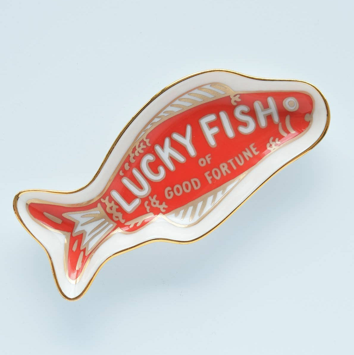 Fish-shaped ornament with 'Lucky Fish of Good Fortune' text on a light blue background