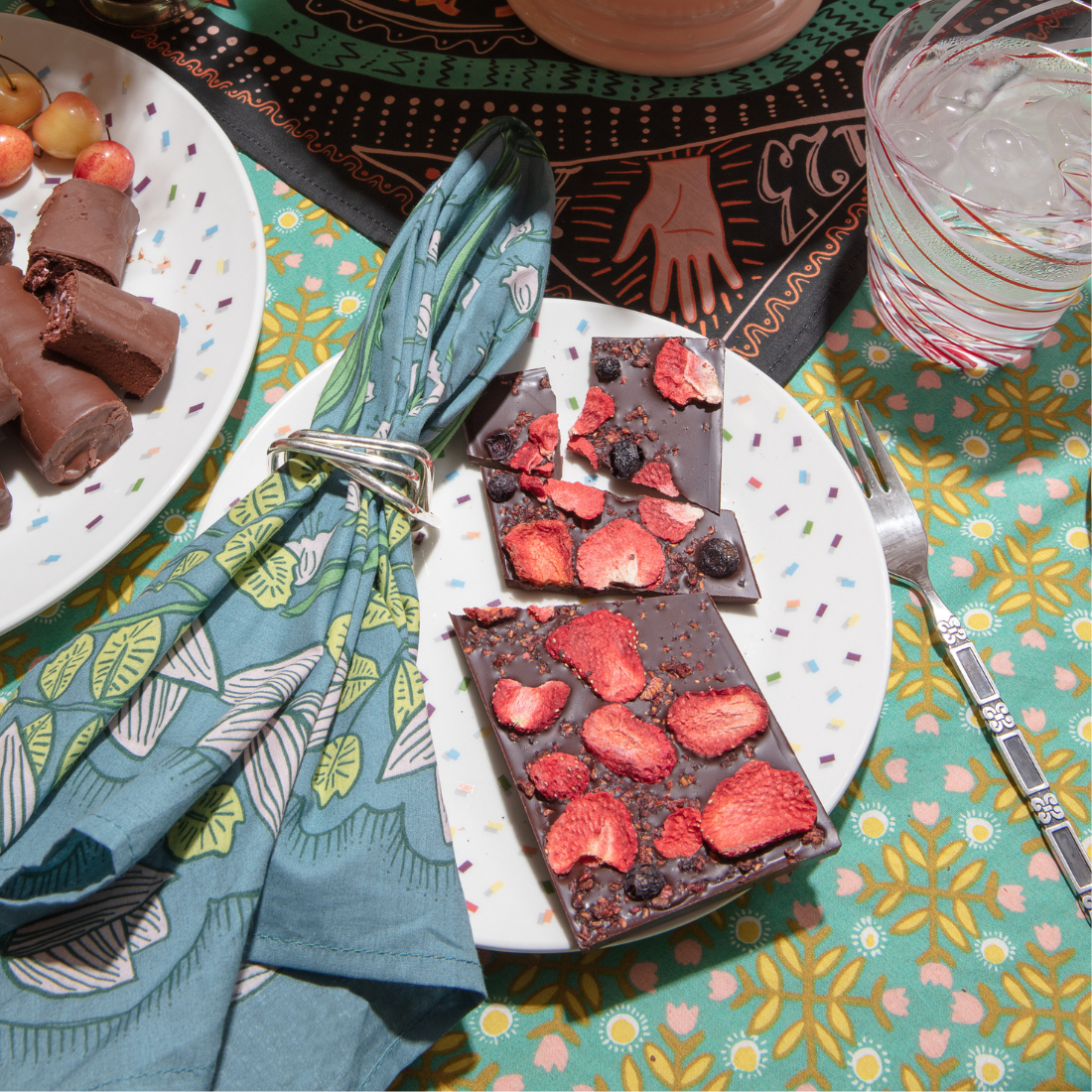 Chocolate bars with berries on a plate with a colorful tablecloth