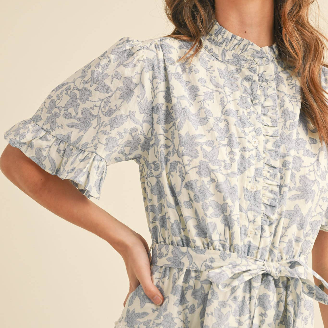 Embrace your softest, most romantic style with this charming ruffled button-down floral mini dress. Every detail is designed to make you feel beautiful—from the delicate ruffled neckline and button placket to the sweet ruffle-trimmed short sleeves. The elastic waistband keeps you comfortable all day, while the self-tying belt lets you define your silhouette just how you like it. Tiered seams adorned with crochet lace add texture and movement, creating a look that feels both playful and put-together.