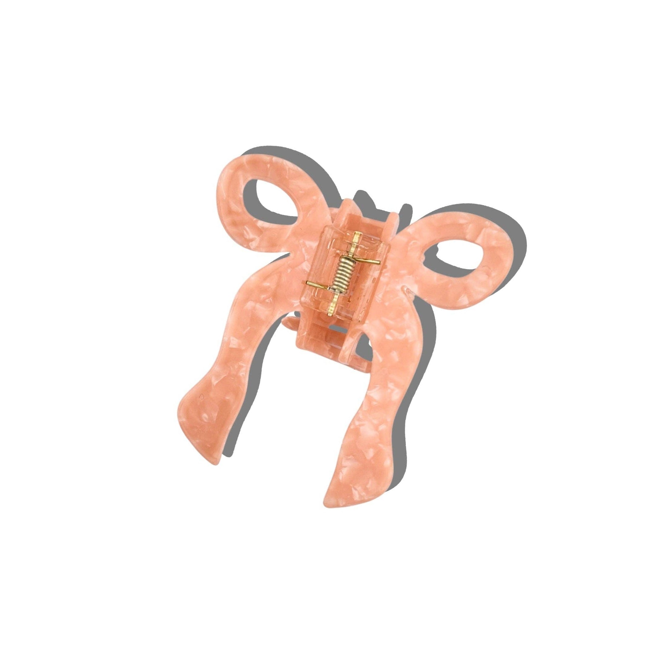 Pink-colored hair clip with a bow on a white background
