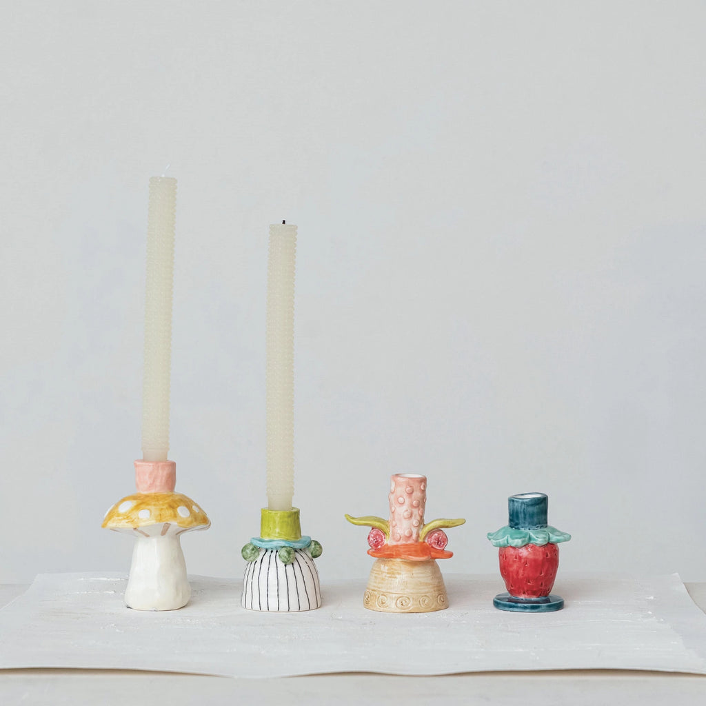 Add a pop of color to your home with this hand-painted stoneware flower taper holder. Each piece is unique and adds a touch of whimsy to any room. Perfect for holding taper candles, this holder is both functional and fun. 2-1/2" Round x 3-3/4"H