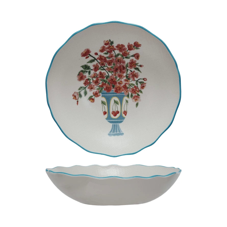 This Country Garden Stoneware Salad Bowl is a delightful addition to any home that cherishes the fusion of functionality and aesthetic charm. The white bowl, accented with a blue rim, showcases a beautiful floral design with blue blossoms and green foliage, reminiscent of a serene country garden. The cross-stitch style texture adds a unique, handcrafted quality to the piece, inviting a sense of warmth and nostalgia to any dining experience.