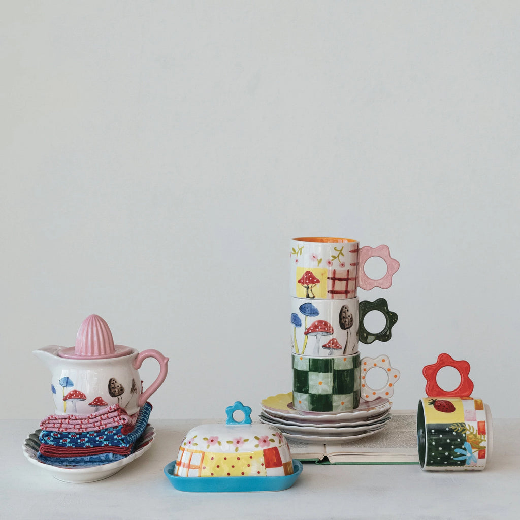 Add a unique touch to your daily coffee routine with our Hand-Painted Stoneware Mug! The flower shaped handle adds a playful twist to this mug while the stoneware material provides durability. Sip on your favorite drink in style with this quirky mug. Hand-Painted Stoneware with Mushroom Design & Pink Flower Handle