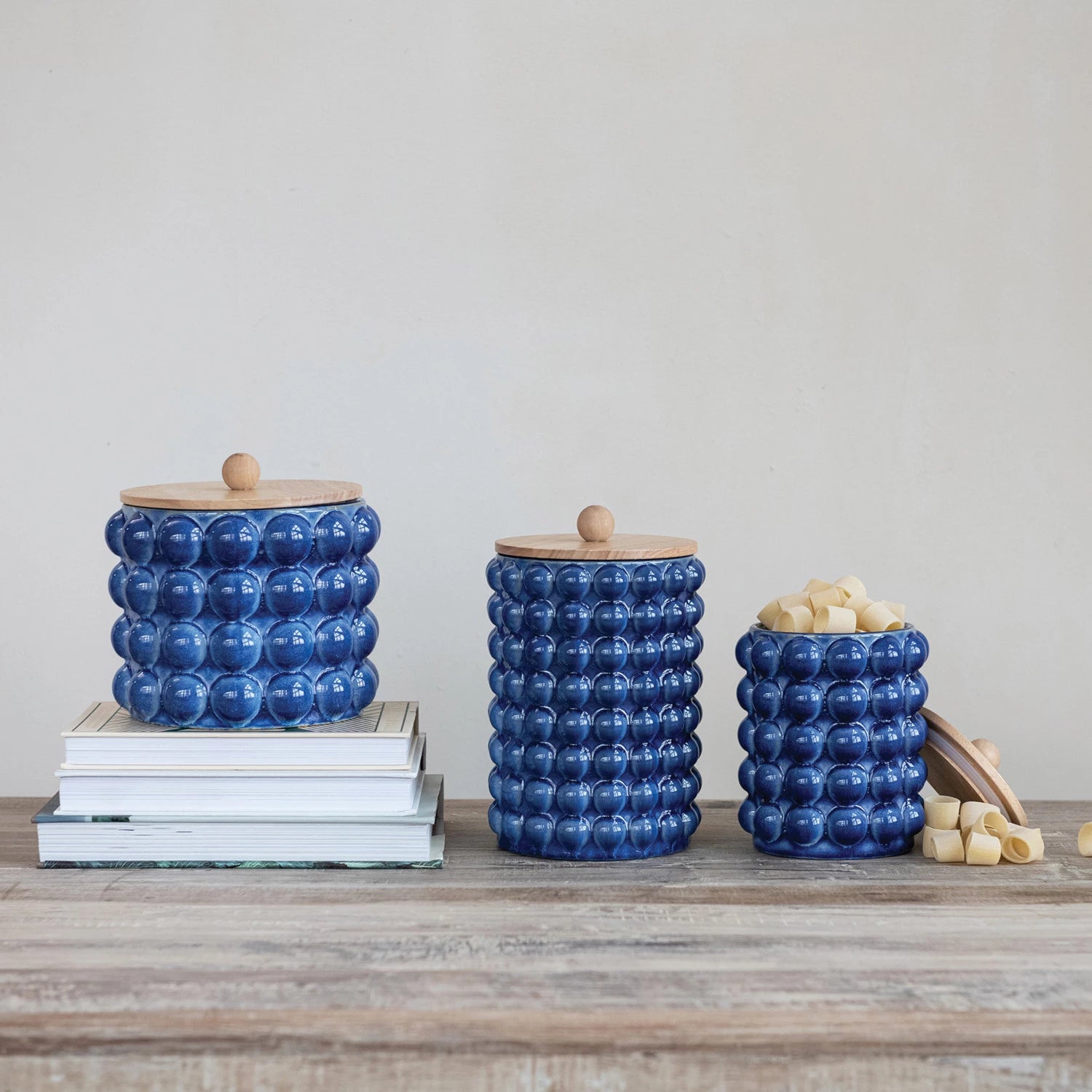 Add a splash of fun to your kitchen with this Blue Raised Dot Stoneware Canister! Its cheerful raised dot texture and vibrant blue color brighten up any countertop while keeping your goodies fresh and within reach. Perfect for storing snacks, coffee, or baking essentials, this sturdy canister combines style and practicality in one playful package. 8-1/4" Round