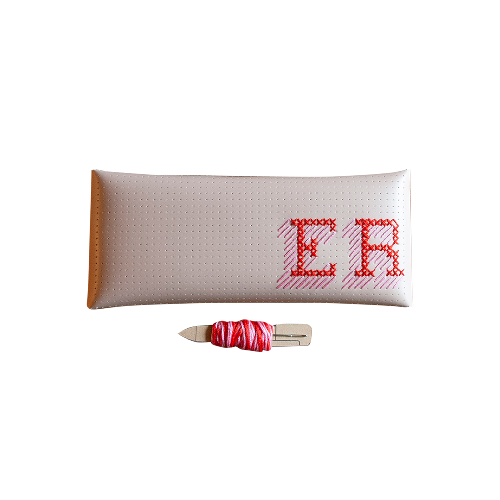 Stitch your own way - this envelope pocket is ideal as a pencil or glasses case and allows you to sew any unique design. Whether you stitch initials, a slogan or the sunglasses template included, it opens out fully for easy stitching. It also opens 2 ways, so it can open from the side or from the top - just pop the metal buttons to fold up whichever way you prefer. The Navy pouch comes with teal & gold thread &amp; needle wrapped on our pen thread-board. It includes our 3D alphabet template to add initials