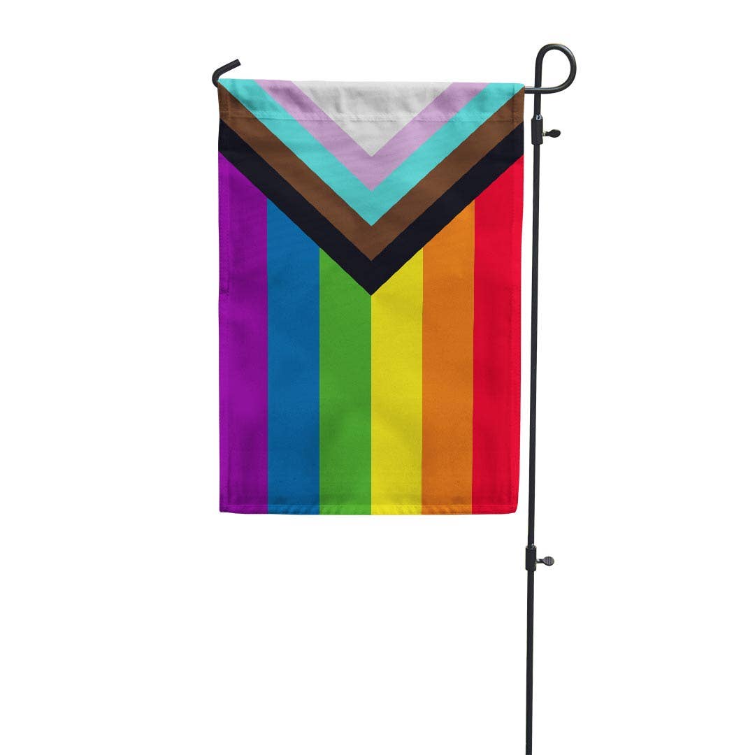 Progress Pride Garden Flag. Designed in 2018 by Daniel Quasar, the "Progress" Flag places 5 half sized stripes in an arrow shape representing trans and non-binary individuals, marginalized POC communities, as well as those living with AIDS on top of the traditional LGBTQ Rainbow Flag.&nbsp;

These garden flags are a thick double-sided construction and double-stitched all around. They have a pole pocket along the top to fit any standard garden flag stake (not included). 18" x 12"