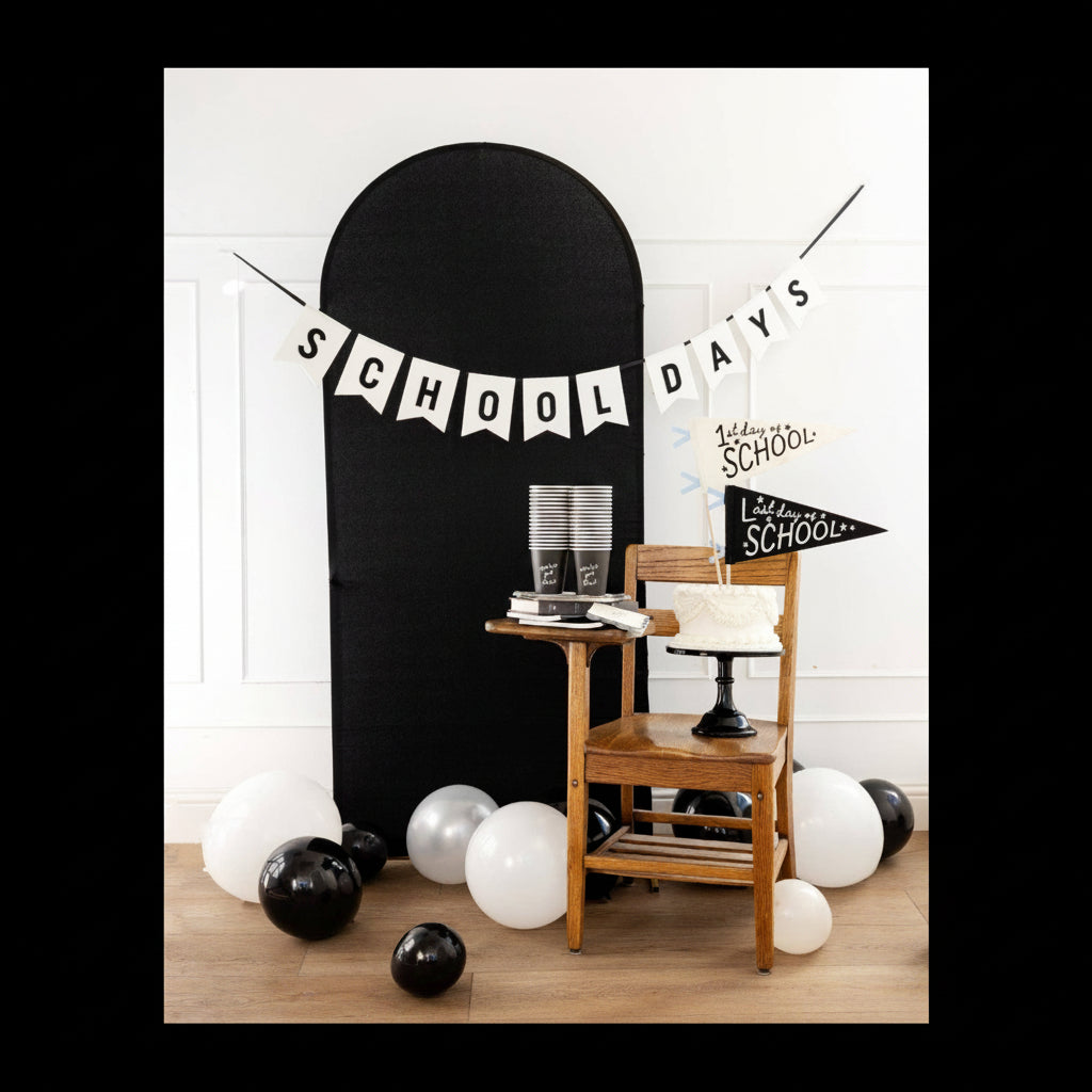 Decorative setup with a blackboard, chair, and balloons for a 'School Days' theme.