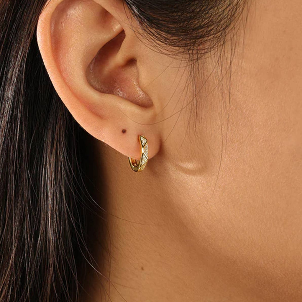 The Triangulum earrings get their name from the galaxy who is undergoing rapid star formation giving it a beautiful glow. Much like their namesake, the CZ triangle edges of these hoops hold brilliant shining czs!

.925 sterling silver with gold plating
Extra layer of tarnish resistance
Manufactured for our curated collection.